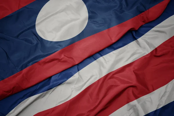 Machanie kolorowa flaga Costa Rica i flaga narodowa Laosu. — Zdjęcie stockowe