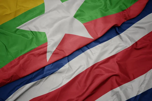 Schwenken bunte Flagge von Costa Rica und Nationalflagge von Myanmar. — Stockfoto