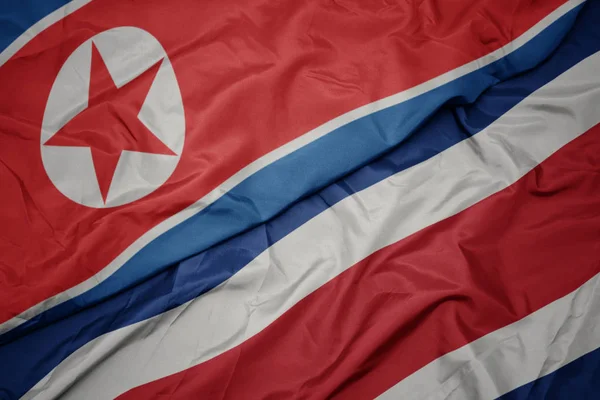 Ondeando colorida bandera de costa rica y bandera nacional de Corea del Norte . —  Fotos de Stock