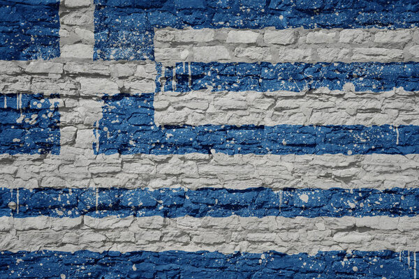 colorful painted big national flag of greece on a massive old brick wall
