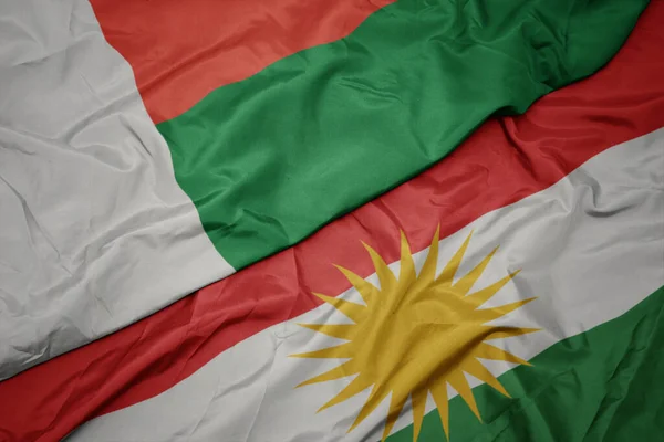 Machając Barwną Flagą Kurdystanu Flagą Narodową Madagaskaru Makro — Zdjęcie stockowe