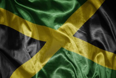 Jamaika 'nın renkli büyük bayrağını ipeksi bir dokuda sallıyordu.