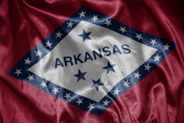 Arkansas eyaletinin renkli, parlak, büyük bayrağını ipeksi bir dokuda sallıyor.
