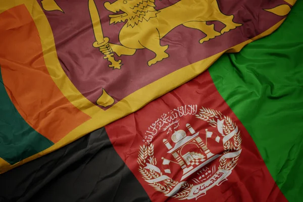 waving colorful flag of afghanistan and national flag of sri lanka.