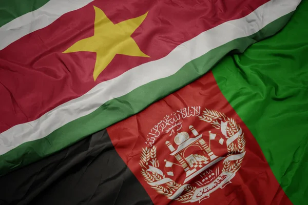 색깔의 아프가니스탄 국기와 수리남 국기를 흔들며 — 스톡 사진