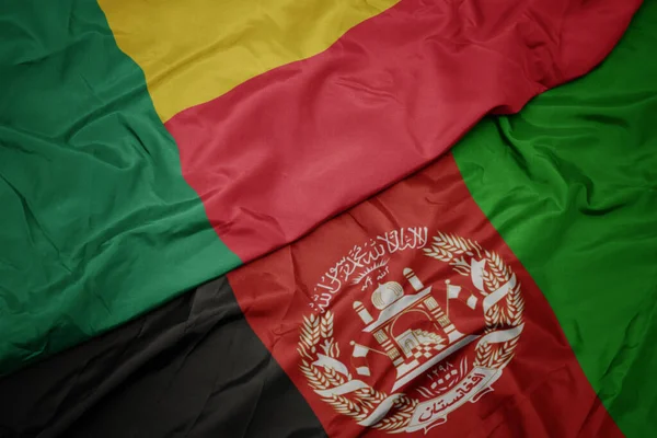 Κυματίζει Πολύχρωμη Σημαία Του Αφγανιστάν Και Εθνική Σημαία Του Μπενίν — Φωτογραφία Αρχείου