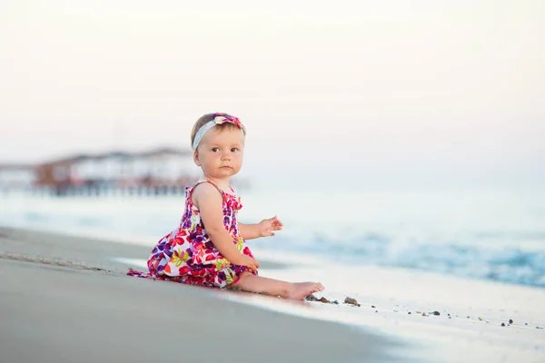 Çocuk kum sahil üzerinde günbatımı zaman oynuyor — Stok fotoğraf