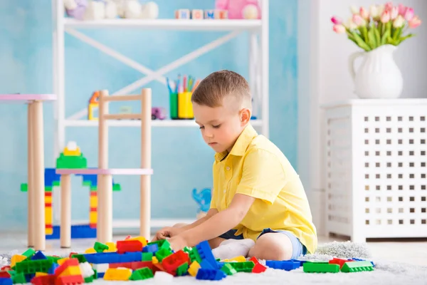 Niño juega en cubos y el diseñador de la casa — Foto de Stock