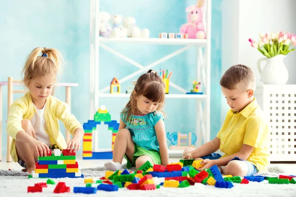 Діти грають вдома на підлозі з кубиками — стокове фото