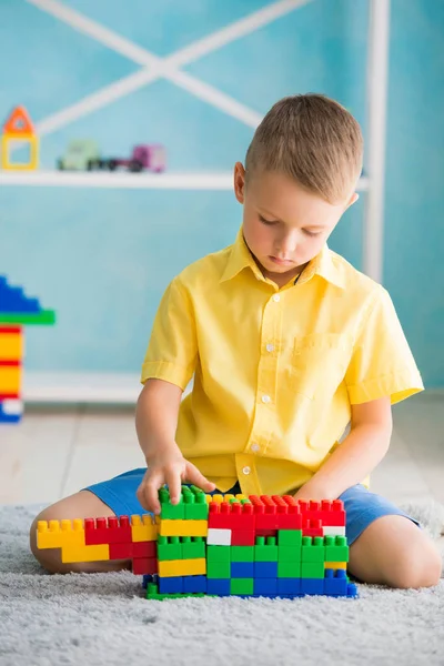 Niño juega en cubos y el diseñador de la casa — Foto de Stock