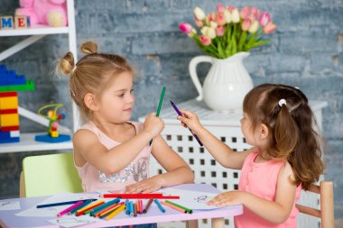 İki güzel kızın ile renkli kalemler çizmek