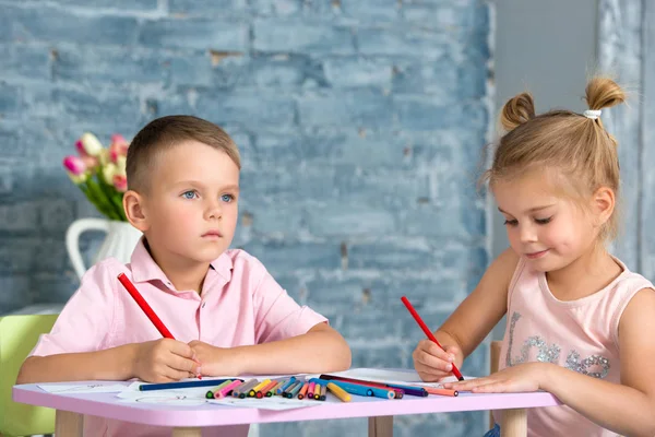 Маленькие дети играют и рисуют цветными карандашами — стоковое фото