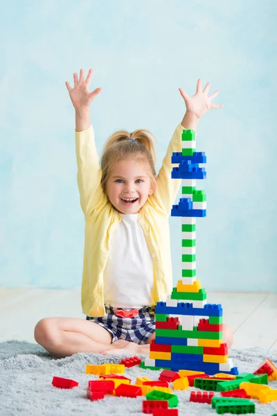 The girl built a tower of cubes. The joy of games — Stock Photo, Image