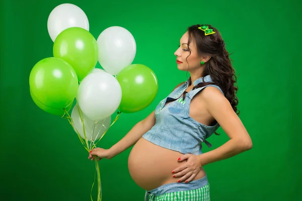 Zwangere Vrouw Met Ballonnen Een Groene Achtergrond Hij Kijkt Naar — Stockfoto