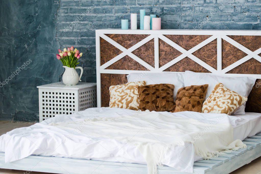 Bedroom with double bed, brick gray wall, loft style.