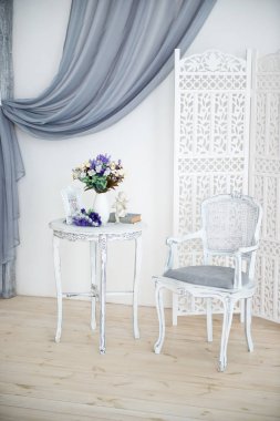 Lüks yatak odası, açık renkli, ayna ve katlanmış ekran. Zarif klasik iç mekan.