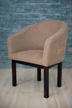 Bej koltuk arka planı gri tuğladan bir duvar. İç.