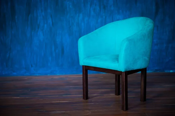 Blue chair against the blue wall. Interior