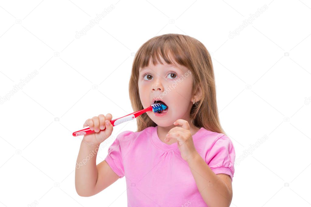Close-up portrait Cute little girl 3 year old in pink t-shirt brushing her teeth isolated on white background.