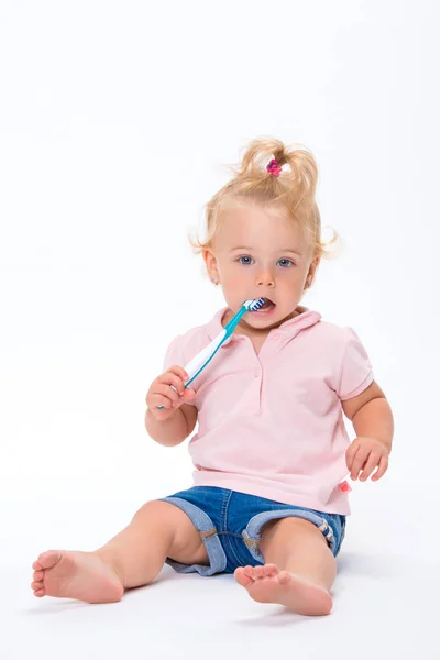 かわいい小さな赤ちゃん女の子 歳ピンクの シャツが白い背景の上分離彼女の歯を磨く — ストック写真