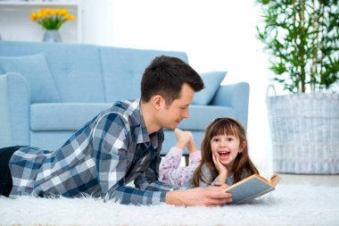 Sevimli küçük kız sıcak yerde birlikte, sevecen babası holding kitap, Aile Hobiler faaliyetleri evde yalan peri masalı okuma baba dinlerken.