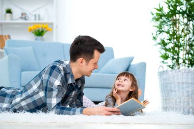 Sevimli küçük kız sıcak yerde birlikte, sevecen babası holding kitap, Aile Hobiler faaliyetleri evde yalan peri masalı okuma baba dinlerken.