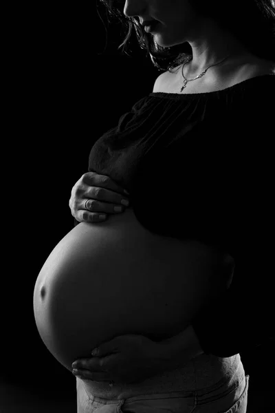 Close-up da barriga grávida em um fundo preto — Fotografia de Stock