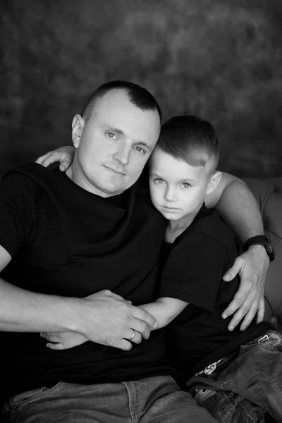 Babası küçük oğlu sarılmak. Closeup kahverengi zemin üzerine aile portresi. Mutlu babalık ve aile sevgisi — Stok fotoğraf