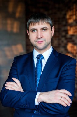 Bir çatı katı iç iş takım elbiseli yakışıklı bir adam portresi. İşadamı geçti silah ile ayakta