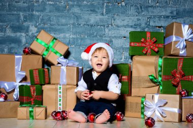 küçük gülen bebek Noel Baba Noel şapka ve iş uygun. Mutlu yeni yıl ve mutlu Noeller. Tatil ve çocuklar için hediyeler