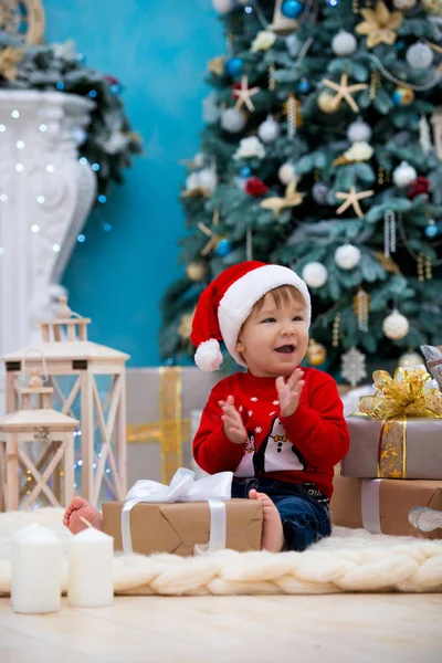 Małe dziecko santa claus w Boże Narodzenie kapelusz. Szczęśliwego nowego roku i Wesołych Świąt. Święta i prezenty dla dzieci — Zdjęcie stockowe