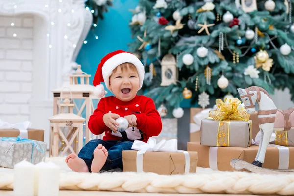 Pequeño bebé santa claus en sombrero de Navidad. Feliz año nuevo y feliz Navidad. Vacaciones y regalos para niños —  Fotos de Stock