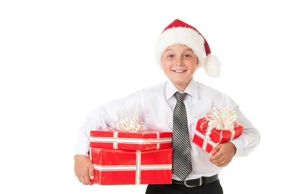 Un niño con una camisa blanca y un sombrero de Papá Noel de Año Nuevo con regalos rojos. Fondo blanco aislado — Foto de Stock