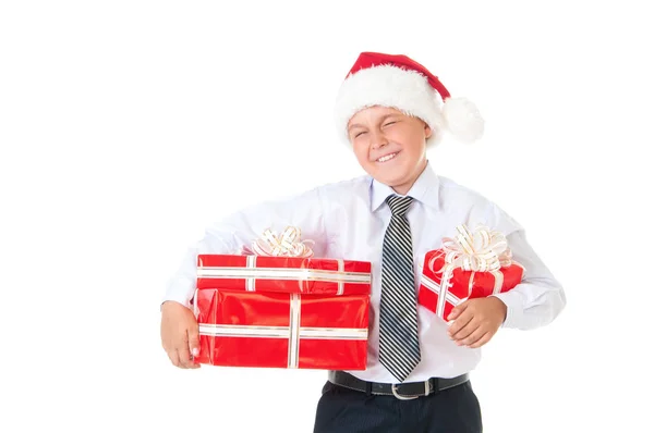 Мальчик в белой рубашке и шляпе новогоднего Санта-Клауса с красными подарками. Изолированный белый фон — стоковое фото