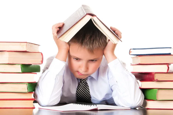 Κουρασμένος, υστερούν μαθητής αγόρι κάθεται σε μια βιβλιοθήκη με βιβλία και μαθαίνει μαθήματα. Απροθυμία να μάθουν — Φωτογραφία Αρχείου