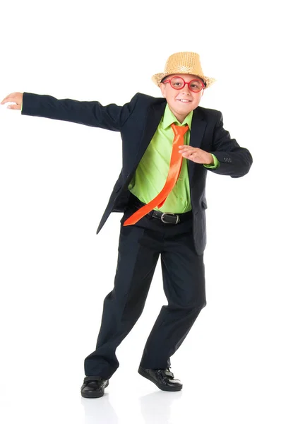 Смешной школьник в деловом костюме, ярком галстуке и смешных очках и шляпе эмоционально танцующей на изолированном белом фоне — стоковое фото