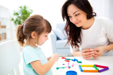 Anne ve küçük kız plastikin yeni ev heykel. Çocuk gelişimi ve eğitim. Bir çocukla aile eğlence. Mutlu çocukluk