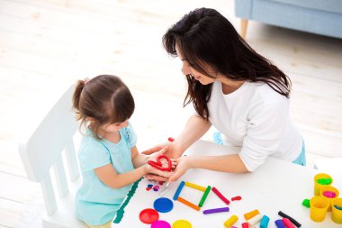 Gülümseyen anne ve kızı heykel kalp ve plastikin yeni ev. Çocuk yaratıcılığı. Mutlu çocukluk. Ev düşleri