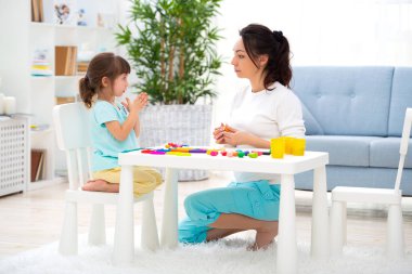 Anne ve küçük kız plastikin yeni ev heykel. Çocuk gelişimi ve eğitim. Bir çocukla aile eğlence. Mutlu çocukluk