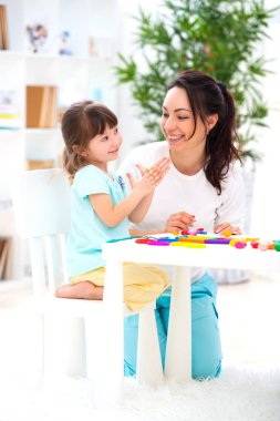 Gülümseyen anne plastikin gelen figürinler heykel için küçük bir kız yardımcı olur. Çocuk yaratıcılığı. Mutlu aile