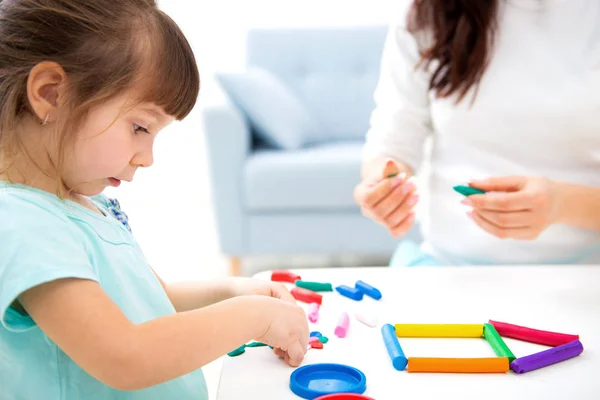 Mom and little daughter sculpt new house of plasticine. Child development and education. Family leisure with a child. Happy childhood — Stock Photo, Image