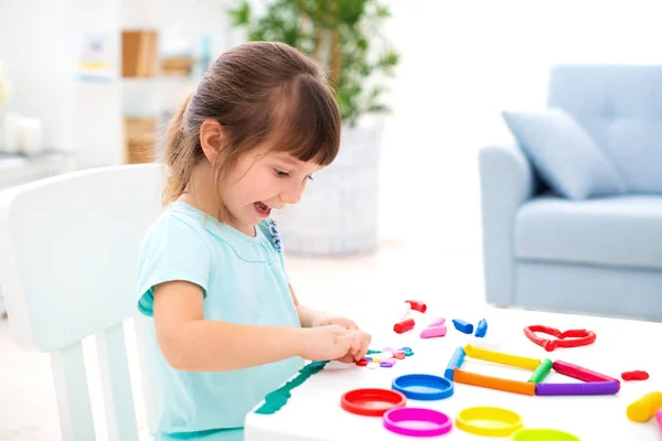 Sorridente bambina bella scolpire nuova casa di plastilina. Creatività dei bambini. Buona infanzia. Sogni d'inaugurazione della casa — Foto Stock