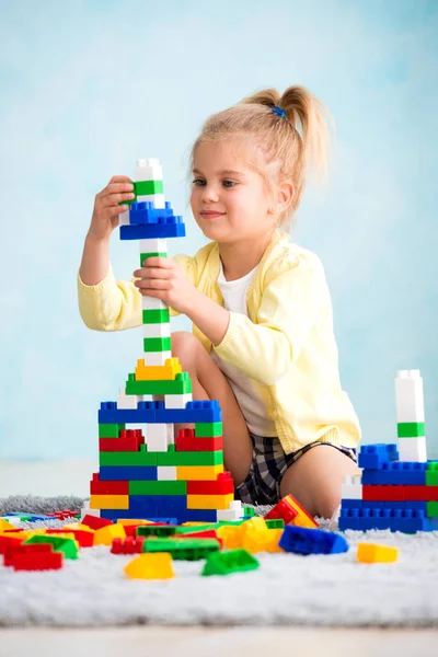 The girl built a tower of cubes. The joy of games — Stock Photo, Image