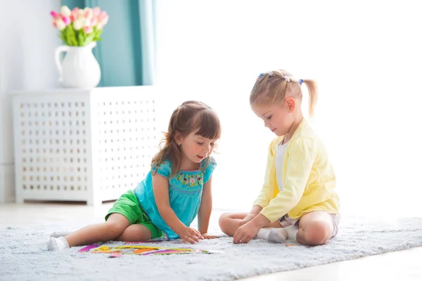 Dwie małe siostry grają razem w domu. — Zdjęcie stockowe