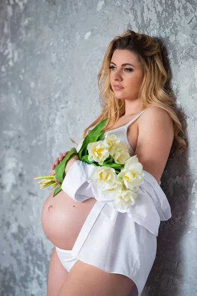 Vacker ung gravid blond kvinna älskar blommor Vita tulpaner. Vårhumör, friskhet, kvinnodagen, hälsa och vackra graviditet — Stockfoto