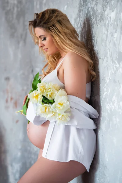 Güzel genç hamile sarışın kadın çiçekler beyaz lale seviyorum. Bahar ruh hali, tazelik, kadınlar günü, sağlık ve güzel gebelik — Stok fotoğraf