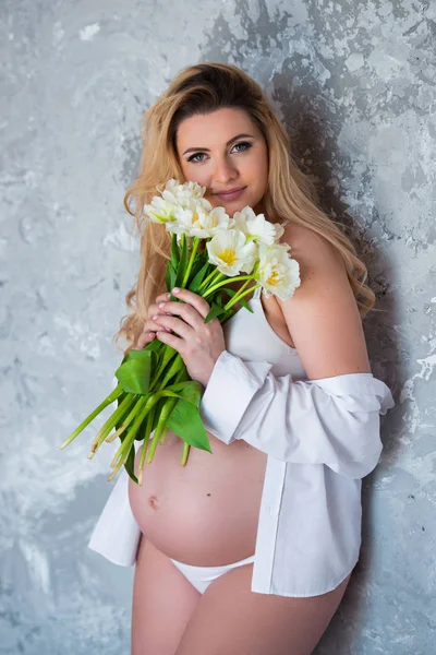 아름 다운 젊은 임신 금발의 여자 사랑 꽃 흰색 튤립입니다. 봄 분위기, 신선도, 여성의 날, 건강과 아름다운 임신 — 스톡 사진