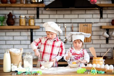 Çocuklar bir erkek ve bir kız un ve yumurta mutfakta lezzetli zencefilli ve kurabiye hazırlamak