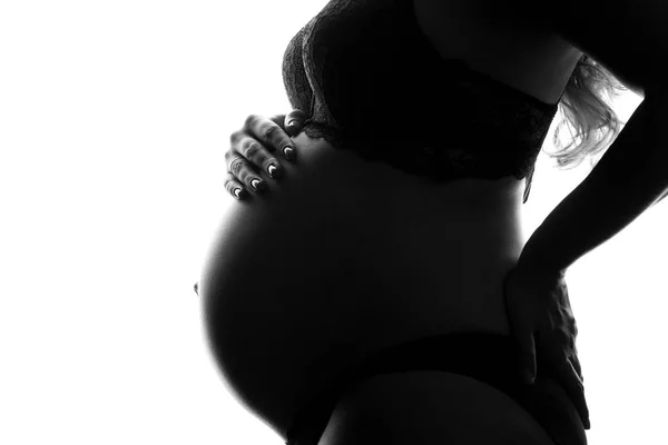 Svartvit bild av kvinnan ömt hålla henne gravid mage uppmärksamt vände sig till sitt ofödda barn. Begreppet graviditet och Happy moderskap — Stockfoto