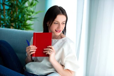 evde kırmızı bir not kitabı ile kız